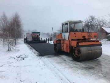 Асфальтування на фоні снігового покриву: у Солом'янському районі Києва спостерігали робітників, які активно працюють над усуненням ожеледиці на дорогах.